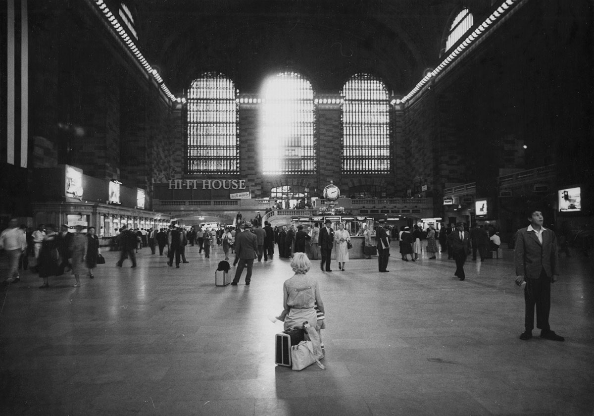 Woman sitting on luggage in Grand Central Terminal, 1958, Anthony Angel