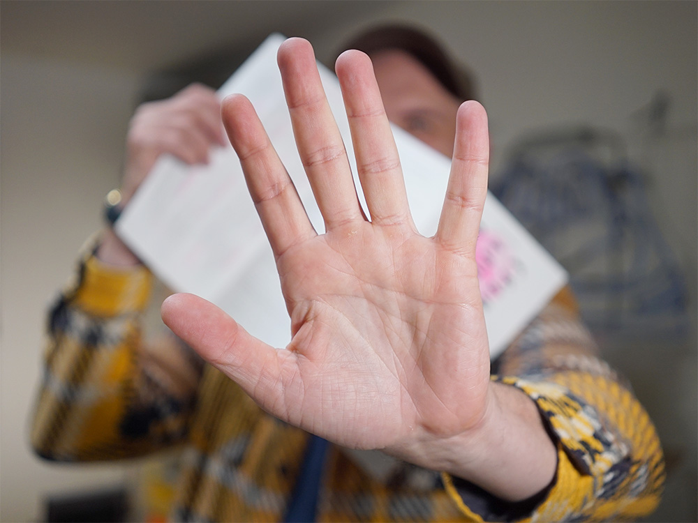 A picture of Robin holding the reverse side of the zine, obscuring it with an outstretched hand.